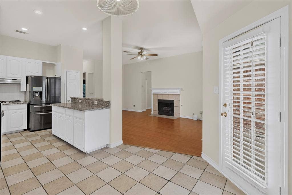 8108 Case Drive, Plano, TX 75025 Kitchen featuring white cabinetry, stainless steel appliances, granite countertops, and tiled flooring