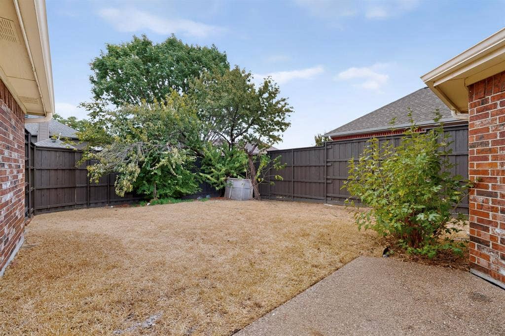 8108 Case Drive, Plano, TX 75025 Private backyard featuring a concrete patio, wood privacy fencing, and mature trees