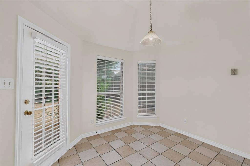 8108 Case Drive, Plano, TX 75025 Vaulted ceiling with pendant lighting, ceramic tile flooring, multiple windows with blinds, and a glass-paneled door