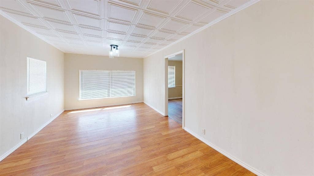 Wood-finish flooring, textured ceiling, flush mount lighting fixture, and window blinds
