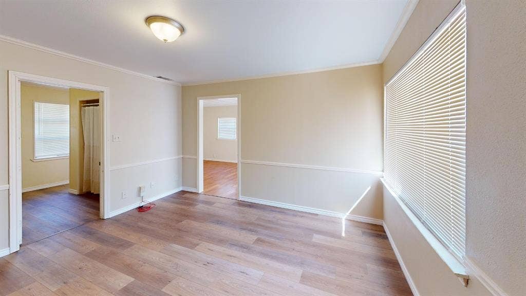 Wood-finish flooring, neutral wall tones, chair rail molding, and a flush mount ceiling light