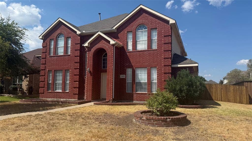 1433 Winterwood Drive, Allen, TX 75002 Red brick exterior with white trim, arched entryway, and multiple windows