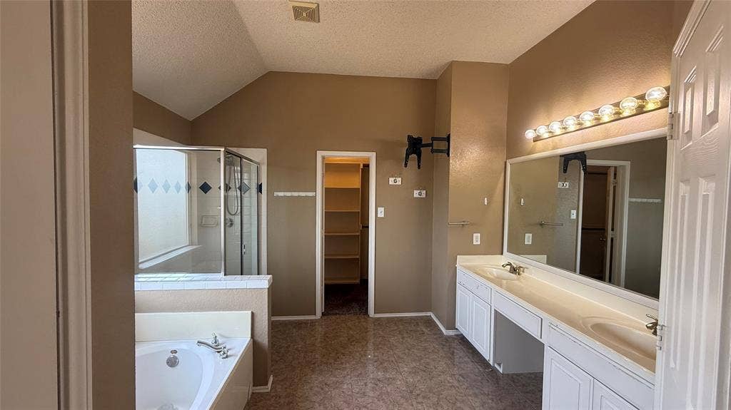1433 Winterwood Drive, Allen, TX 75002 Dual vanity with integrated sinks, built-in soaking tub, glass-enclosed shower, vaulted ceiling, and built-in shelving