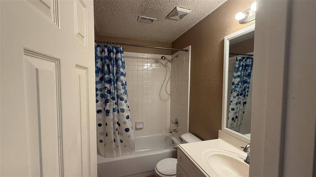 1433 Winterwood Drive, Allen, TX 75002 Tub and shower combination with white subway tile surround, single vanity with integrated sink, and framed mirror