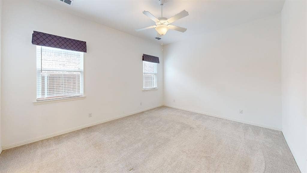 3285 Dover Drive, McKinney, TX 75069 Wall-to-wall carpeting, two windows with blinds, a ceiling fan with integrated lighting, and neutral wall tones