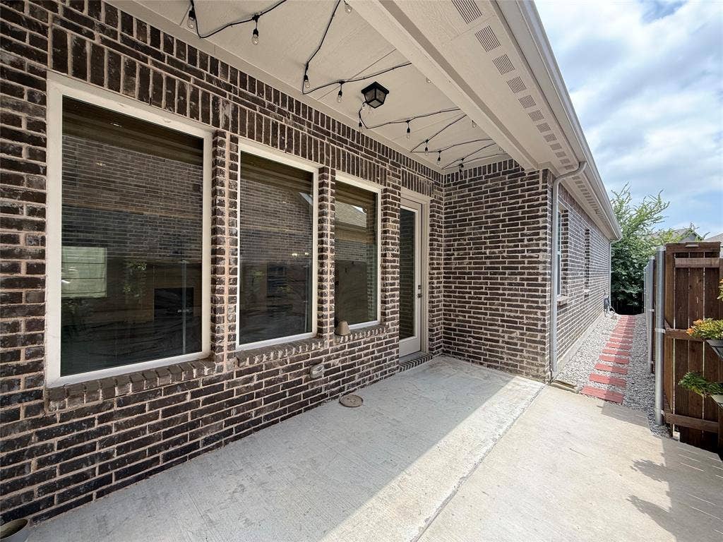 3285 Dover Drive, McKinney, TX 75069 Brick exterior with white window trim and a concrete patio