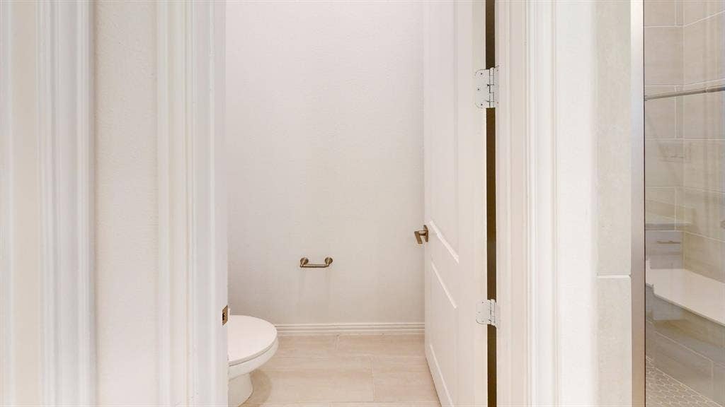 3285 Dover Drive, McKinney, TX 75069 Powder room featuring a toilet, tile flooring, and a glass-enclosed shower with a built-in bench