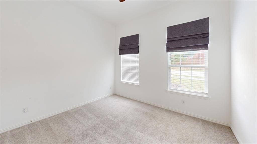 3285 Dover Drive, McKinney, TX 75069 Neutral tone walls, ceiling-mounted light fixture, light-toned carpet flooring, and two windows with blinds and fabric shades