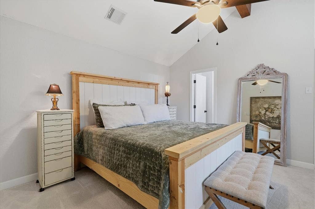 Another view of the primary suite highlights the vaulted ceiling and generous room for a king-size bed.