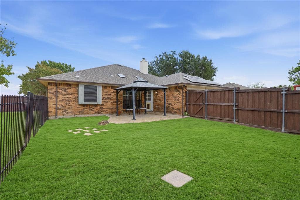 Spacious fenced backyard provides plenty of room for play, pets and outdoor entertaining, with a covered patio just off the home.