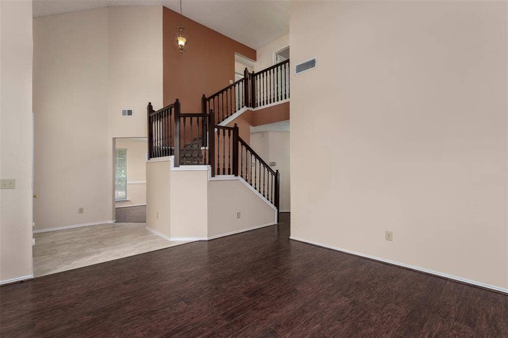 4500 Fargo Drive, Grand Prairie, TX 75052 Vaulted ceiling with a hanging fixture, wood-finish flooring, and a multi-level staircase with dark wood railings