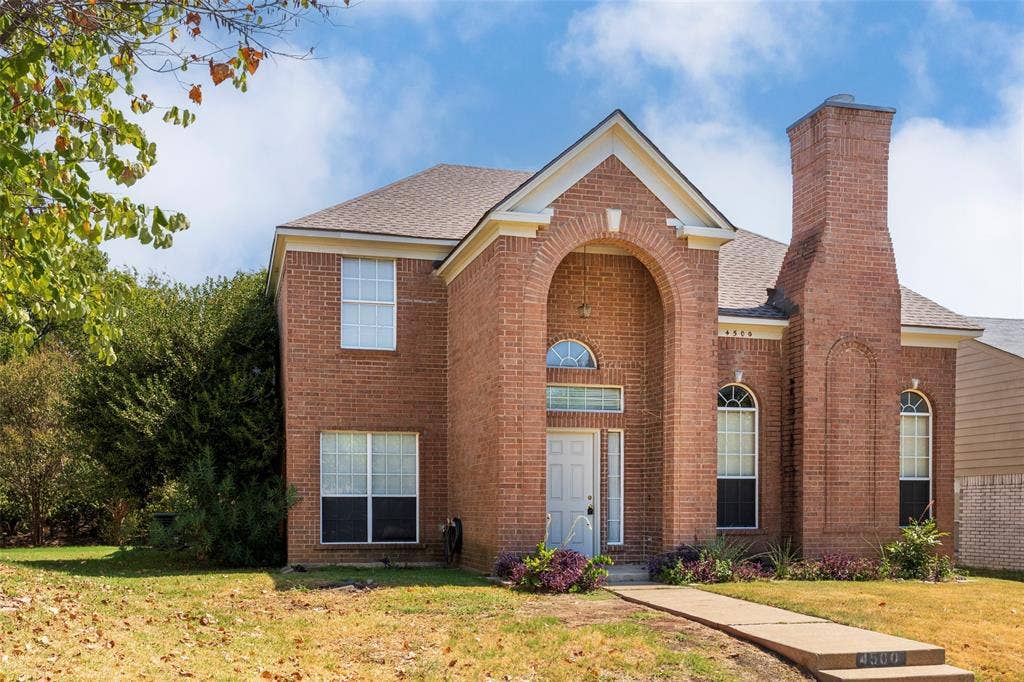 4500 Fargo Drive, Grand Prairie, TX 75052 Brick exterior with an arched entry, prominent brick chimney, and a concrete pathway leading to the front door