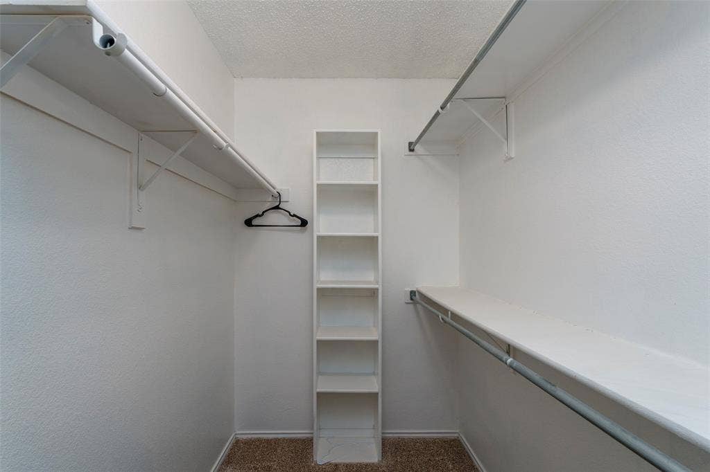 4500 Fargo Drive, Grand Prairie, TX 75052 Walk-in closet featuring built-in shelving, white walls, and a textured carpeted floor