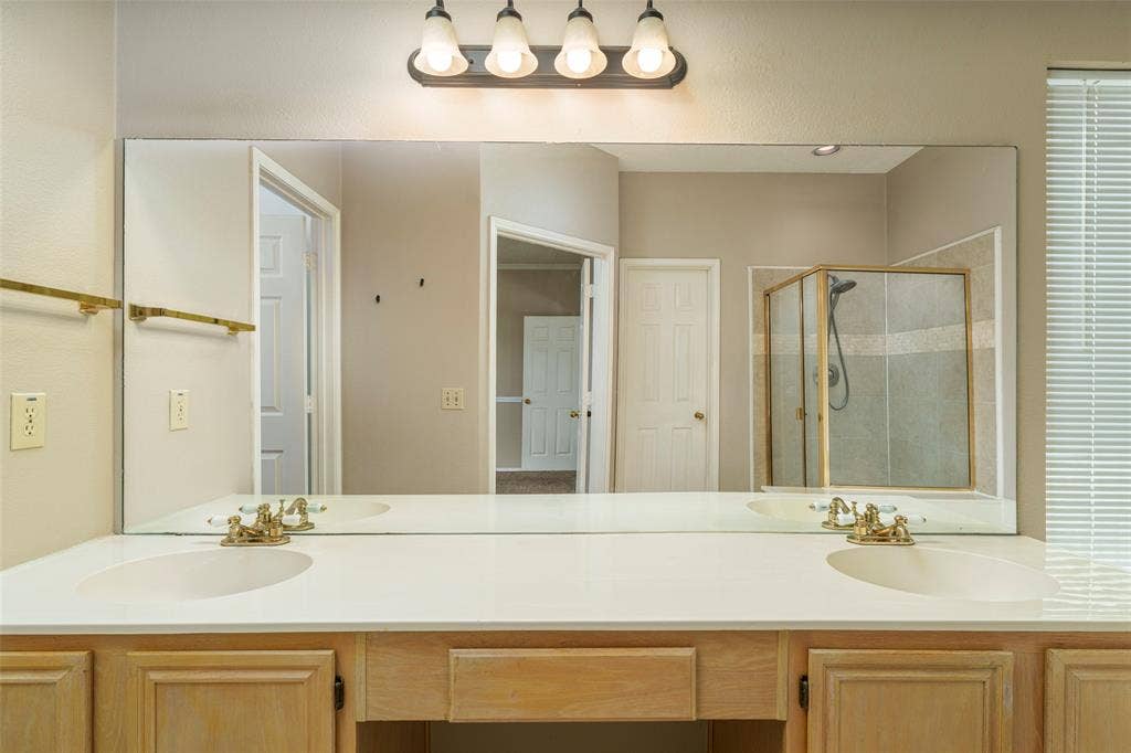 4500 Fargo Drive, Grand Prairie, TX 75052 Dual sink vanity with light wood-finish cabinetry and a single light fixture