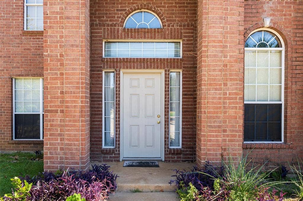 4500 Fargo Drive, Grand Prairie, TX 75052 Red brick exterior featuring a white paneled entry door with sidelights