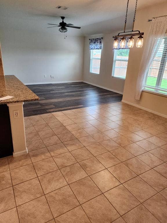 729 Watson Way, Crowley, TX 76036 Empty room featuring a healthy amount of sunlight, light hardwood / wood-style floors, and ceiling fan with notable chandelier