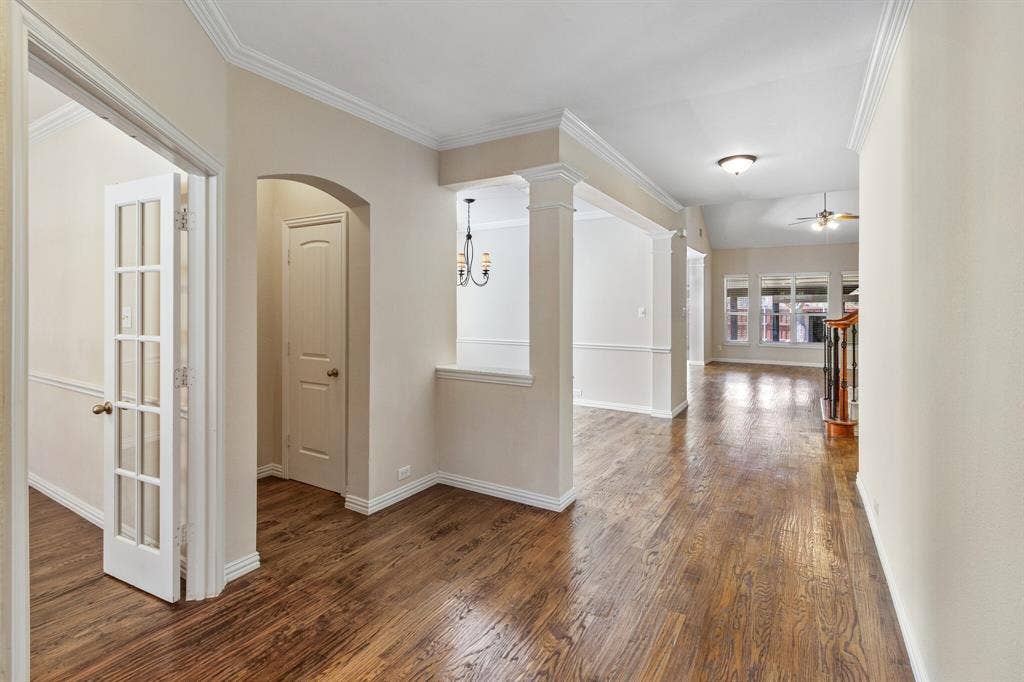 4908 Rushden Road, McKinney, TX 75070 Hardwood-finish flooring throughout, decorative columns, crown molding, and an arched doorway