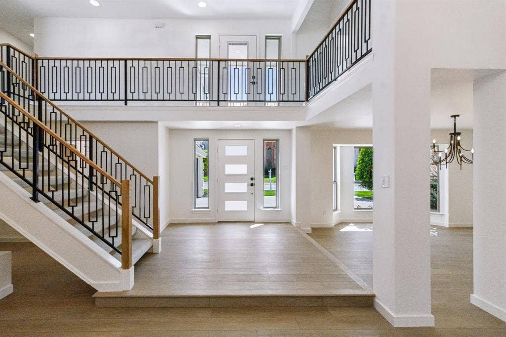 6029 Buffridge Trail, Dallas, TX 75252 New front door and modern staircase railing from main stairs to the run all around the living room.