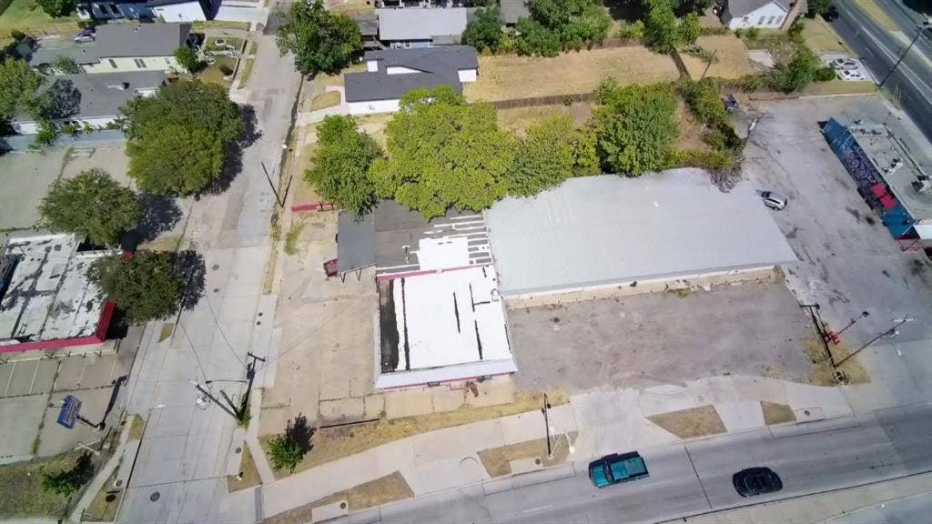 4606 Botham Jean Boulevard, Dallas, TX 75215 Building with a metal roof, an adjacent flat-roofed structure, and a paved lot