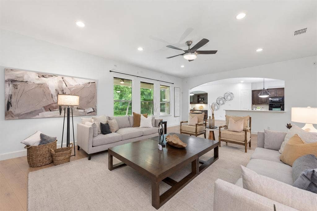 Spacious living area featuring wood-finish flooring, recessed lighting, and a ceiling fan