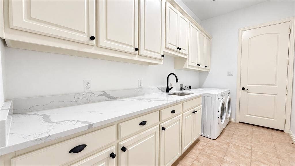 Extensive countertop space featuring a dual-basin sink, white shaker-style cabinetry with matte black hardware, and tiled flooring