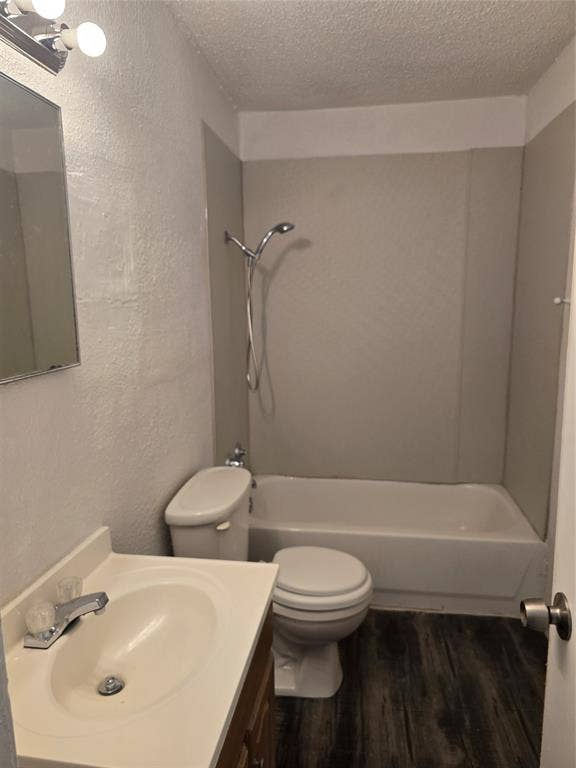 409 Monica Drive, Garland, TX 75041 Bathroom featuring wood-finish flooring, a white vanity with an integrated sink, a built-in bathtub, and a shower with a chrome fixture