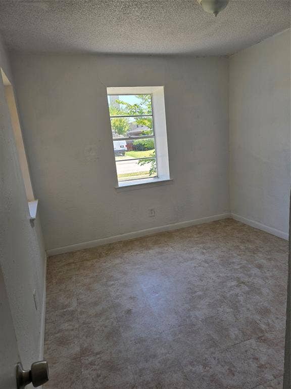 409 Monica Drive, Garland, TX 75041 Neutral wall paint, textured ceiling, tile-look flooring, and a single window