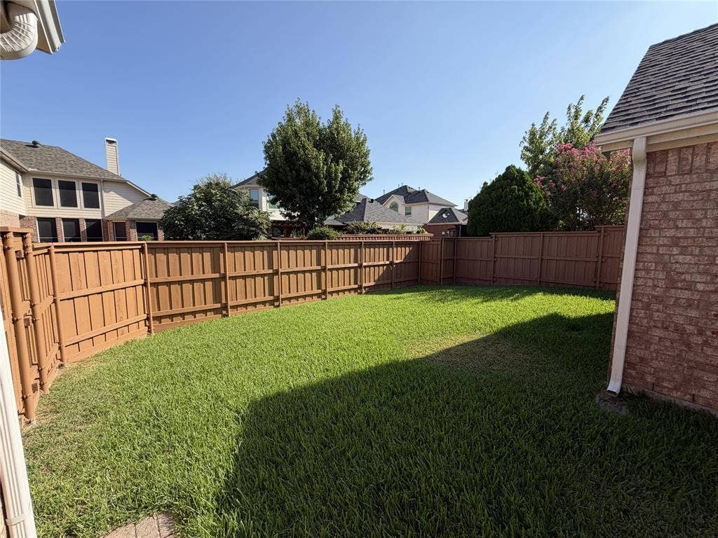 4413 Jenkins Drive, Plano, TX 75024 Expansive backyard featuring a manicured lawn, full perimeter privacy fencing, and brick exterior