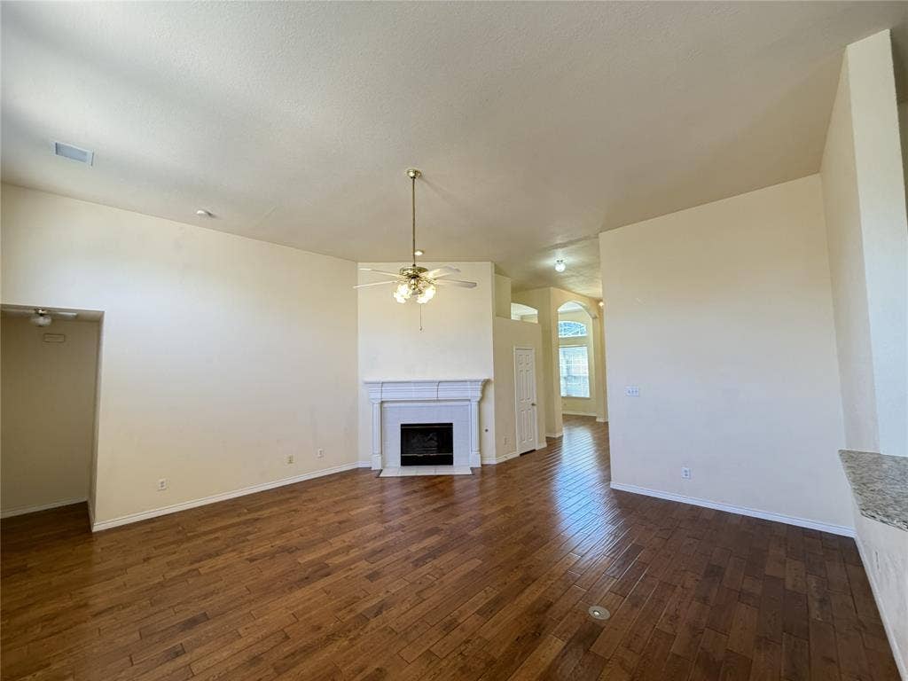 4413 Jenkins Drive, Plano, TX 75024 Vaulted ceilings, wood-finish flooring, and a fireplace with a mantel