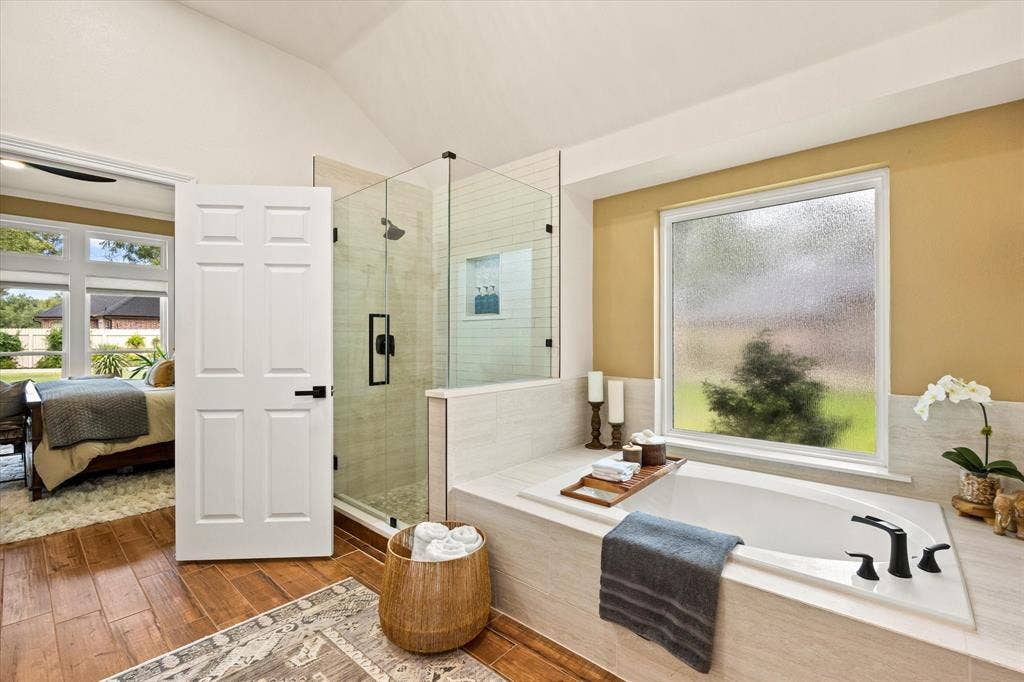 9604 Champions Drive, Granbury, TX 76049 Large En Suite Primary Bathroom Featuring Large Garden Tub with New Tile Surround, Updated Shower with Frameless Glass Door, Kohler Fixtures and Designer Paint