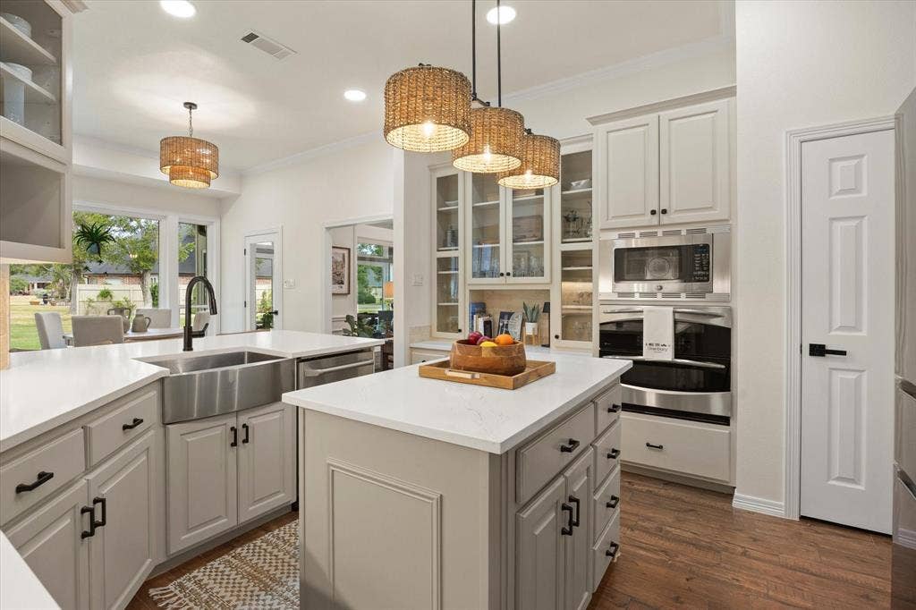 9604 Champions Drive, Granbury, TX 76049 Stainless Steel Farmhouse Sink with Designer Faucet, Double Oven, Microwave, Custom Cabinets with Built-In Menu Planning Desk Complete this Chef's Kitchen