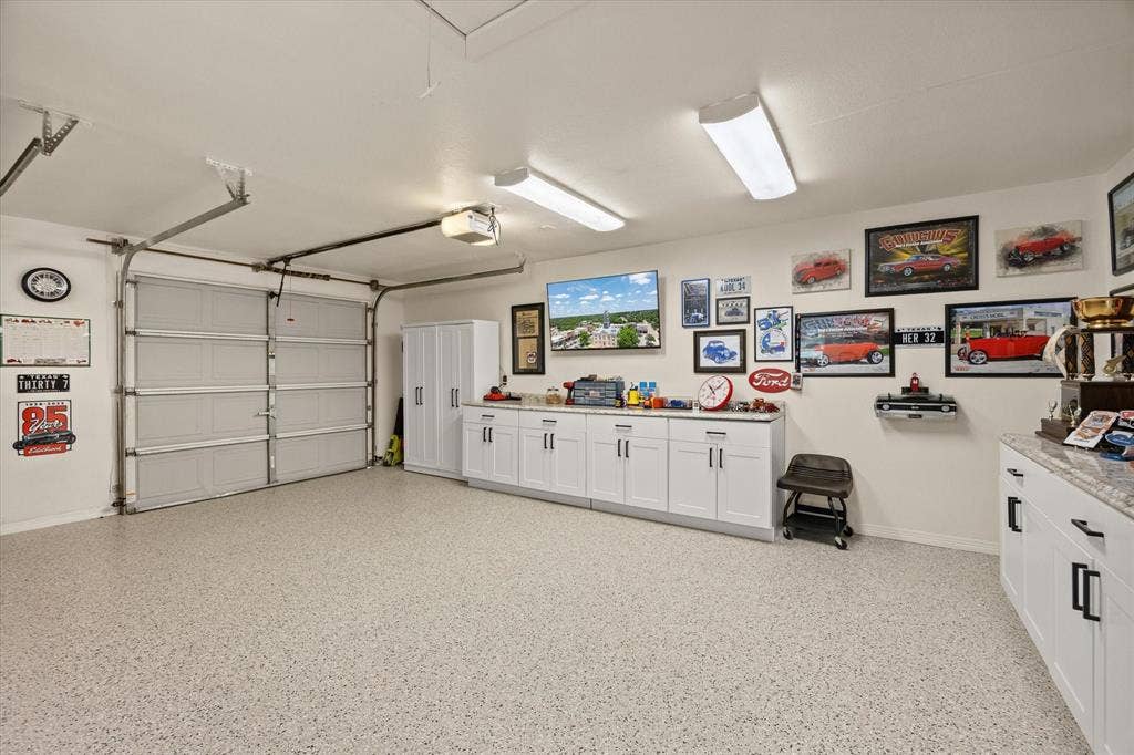 9604 Champions Drive, Granbury, TX 76049 Oversized 3 Car Garage with Epoxy Flooring, New Overhead LED Light Fixtures, New Ceiling Fan and New Metal Pull Down Attic Stairs. All Cabinets will Remain with the Home
