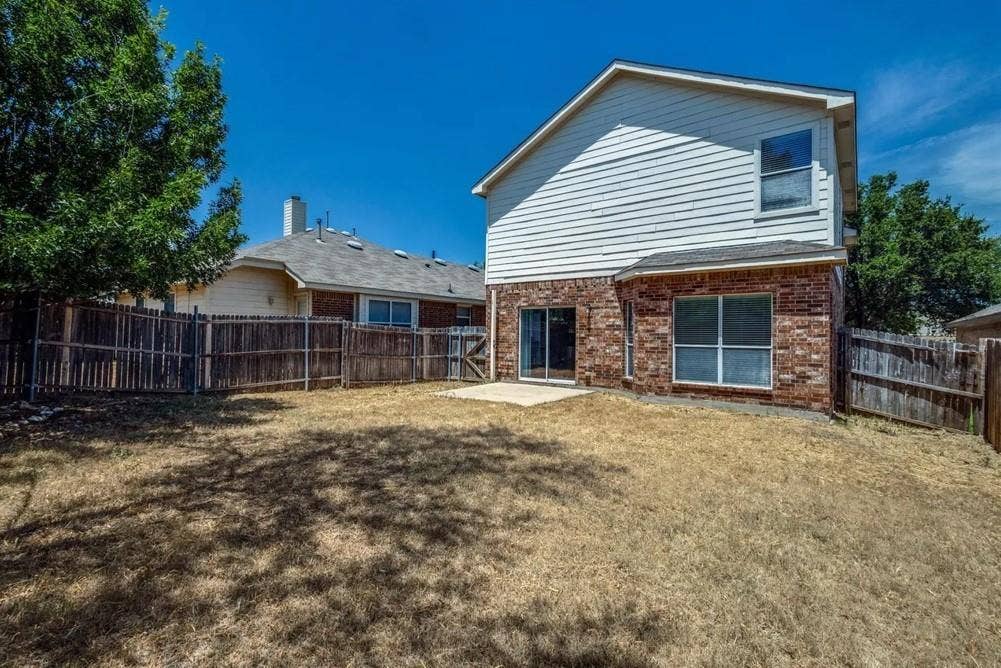 Exterior featuring brick and siding finishes, a patio area, and a fenced backyard