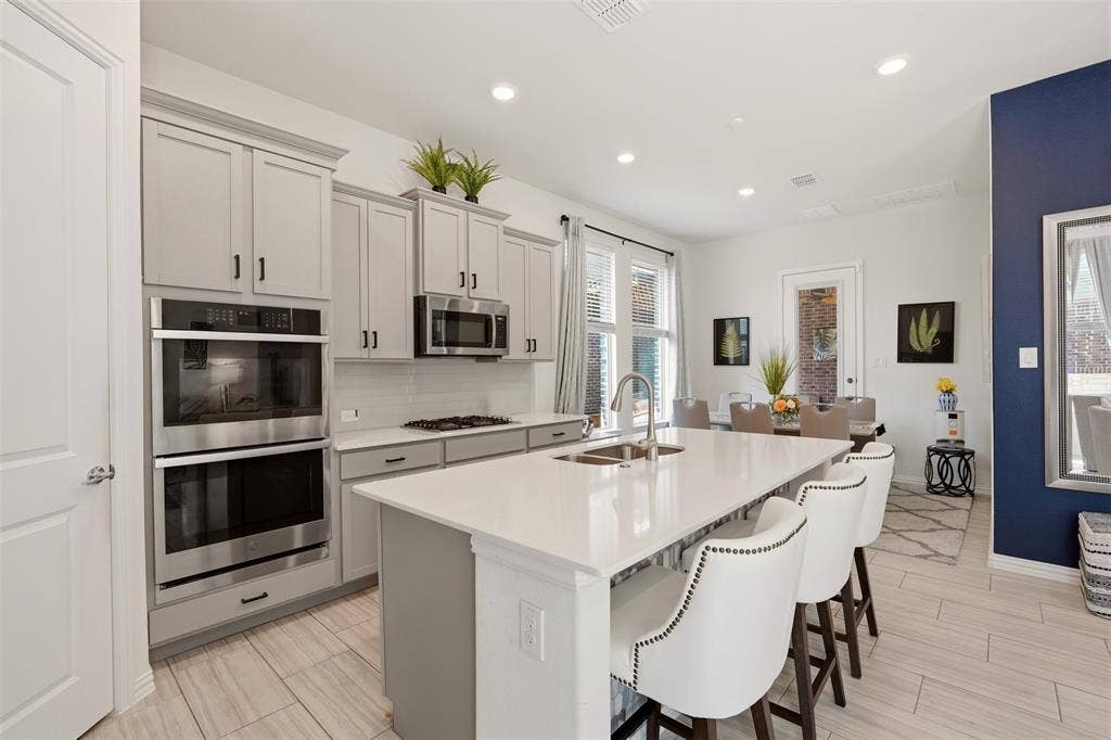 4808 Forest Crest Parkway, Arlington, TX 76005 Kitchen featuring recessed lighting, a kitchen island with sink, light-toned cabinetry, stainless steel double ovens, and wood-finish flooring