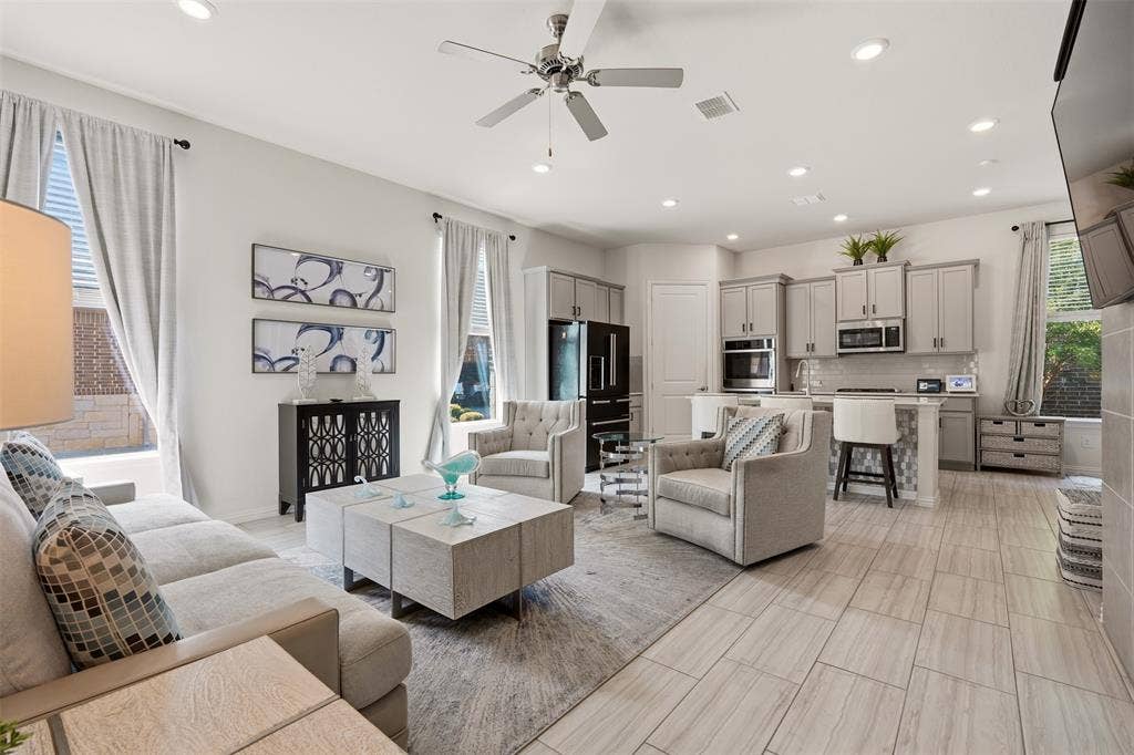 4808 Forest Crest Parkway, Arlington, TX 76005 Open-concept living space with light-tone tile flooring, recessed lighting, ceiling fan, and kitchen featuring light gray cabinetry and stainless steel appliances