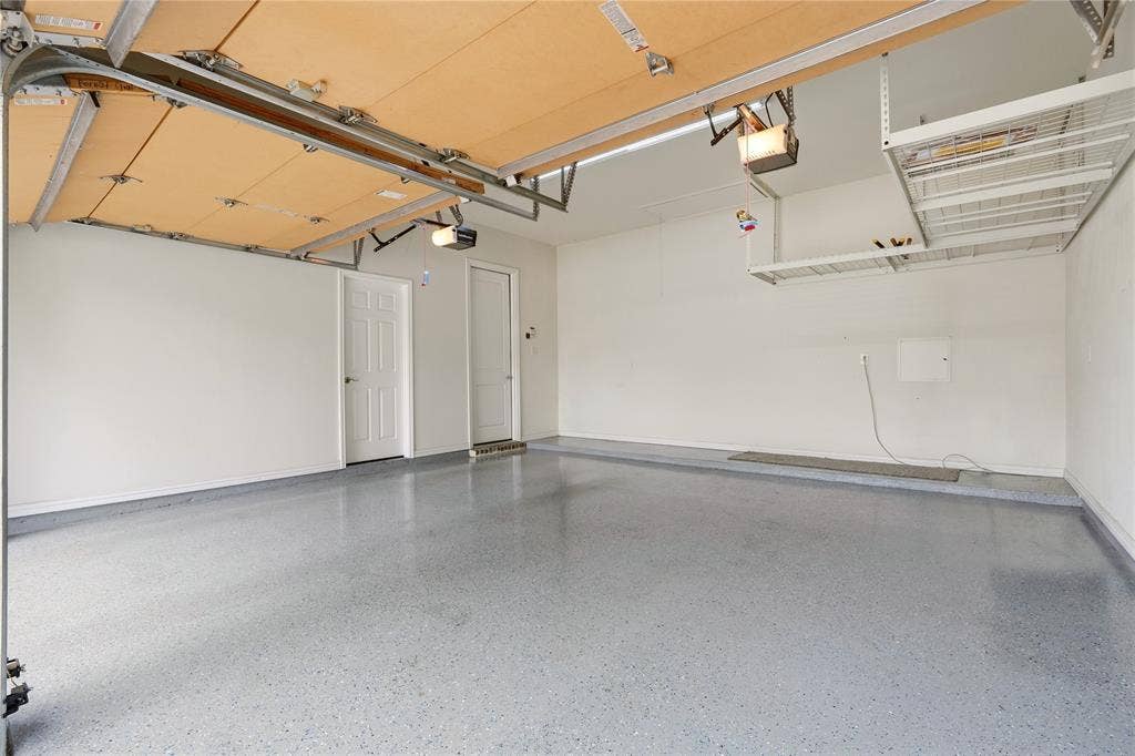 4808 Forest Crest Parkway, Arlington, TX 76005 Spacious garage with light grey speckled flooring, white walls, and built-in overhead storage racks