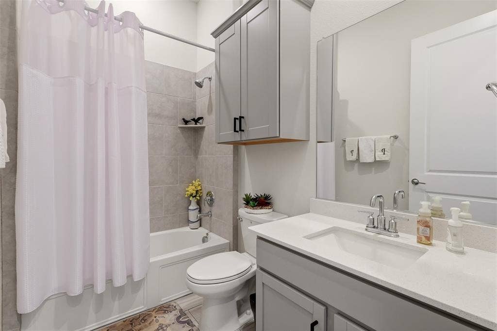 4808 Forest Crest Parkway, Arlington, TX 76005 Full bathroom featuring a tub/shower combination with light gray tile surround, single vanity with integrated sink, and gray cabinetry