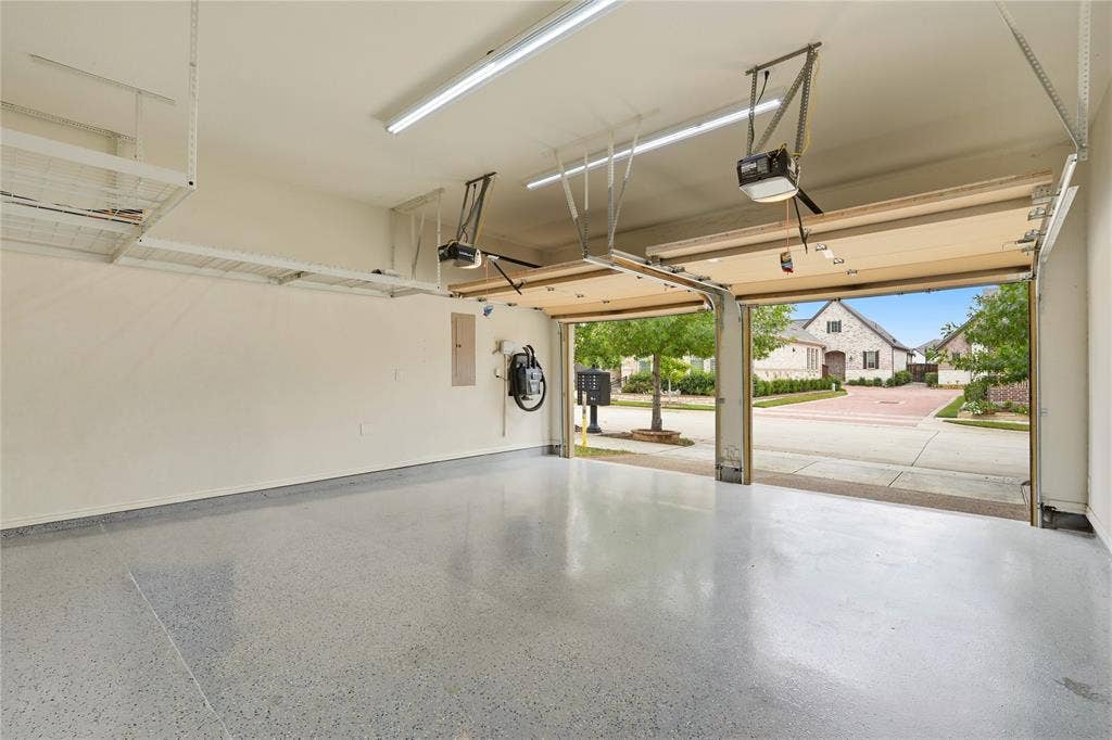 4808 Forest Crest Parkway, Arlington, TX 76005 Two-car garage with epoxy-coated flooring, overhead storage racks, and fluorescent lighting