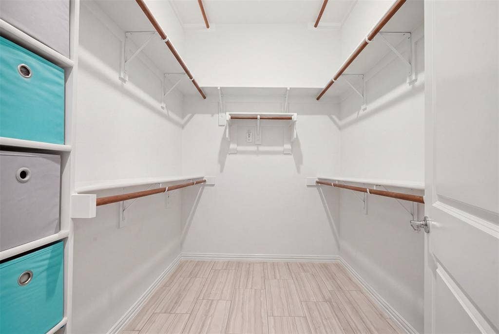 4808 Forest Crest Parkway, Arlington, TX 76005 Spacious walk-in closet featuring wood-finish flooring, multiple shelving units, and ample hanging rods