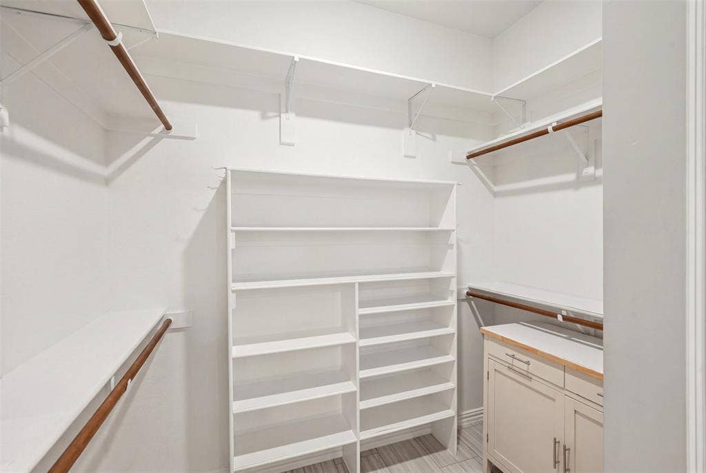4808 Forest Crest Parkway, Arlington, TX 76005 Built-in closet system with multiple shelving units, hanging rods, and a lower cabinet with a wood-finish countertop