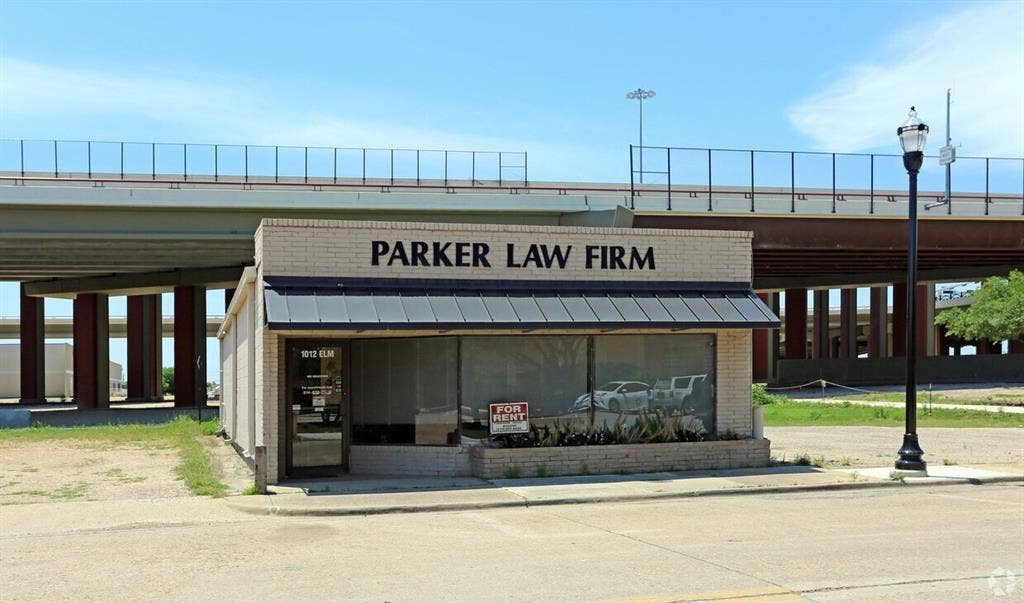 1012 S Elm Street, Carrollton, TX 75006 Single-story commercial building featuring a brick facade and dark metal awning