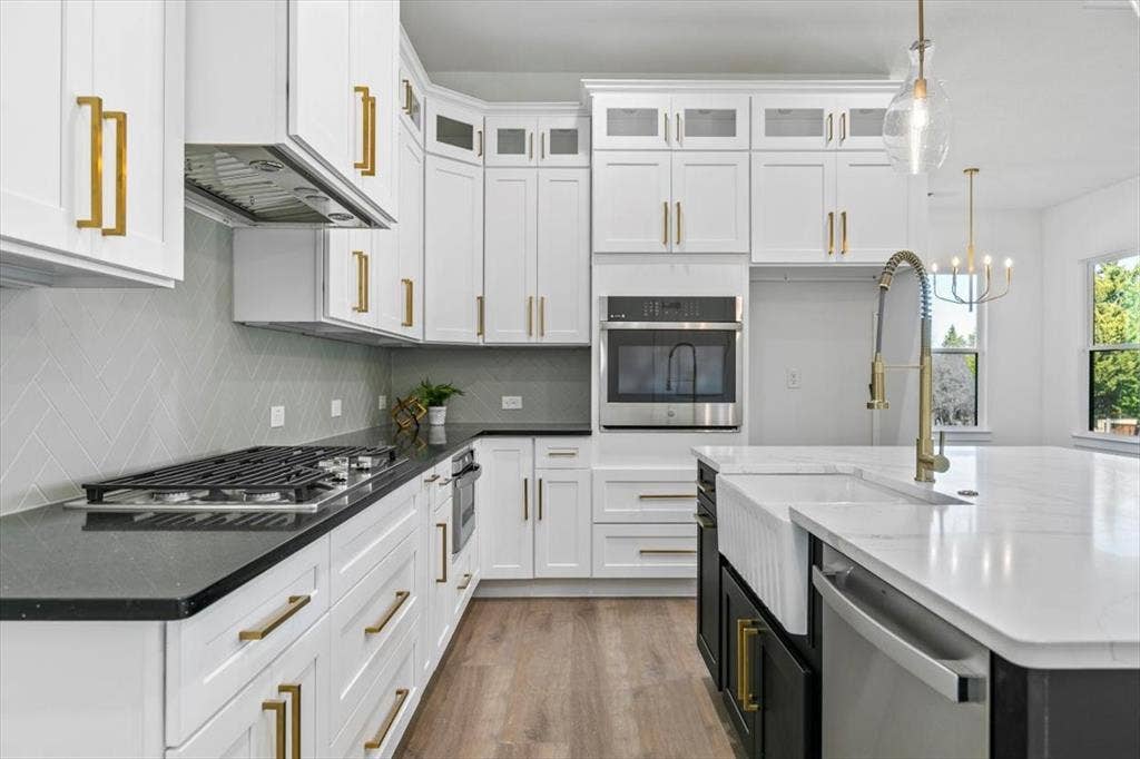 Lovely kitchen with gas cooktop, stainless steel appliances and lighted upper cabinets.