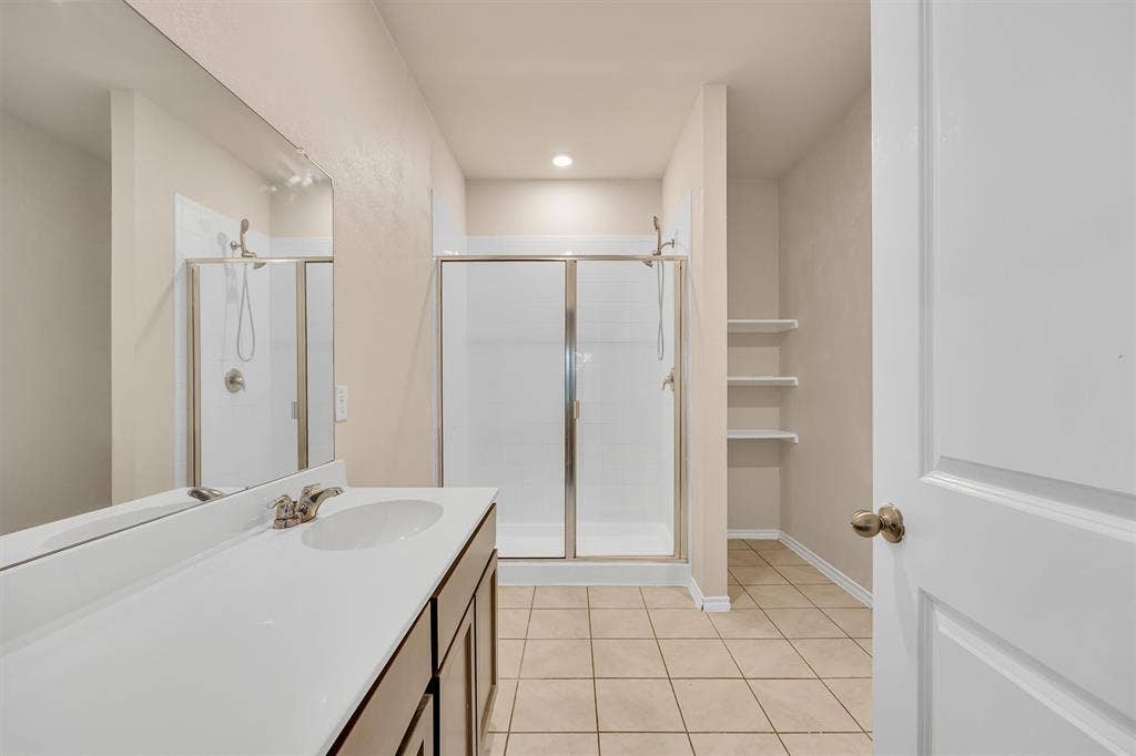 Vanity with integrated sink, brushed nickel faucet, and wood-finish cabinetry