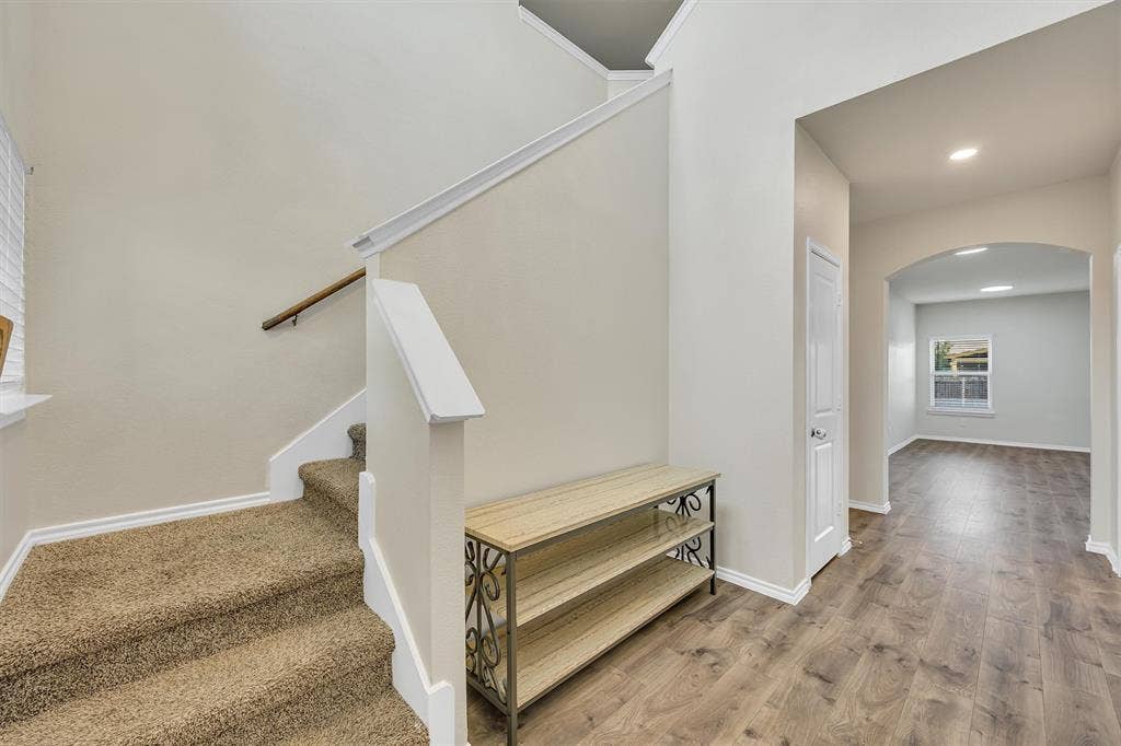 Carpeted staircase with wooden handrail