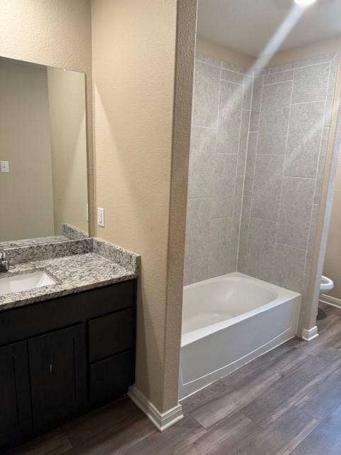Bathroom featuring a built-in vanity with a granite countertop, undermount sink, and dark wood-finish cabinetry