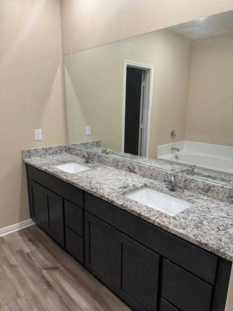 Dual vanity featuring undermount sinks, granite countertops, and dark wood-finish cabinetry