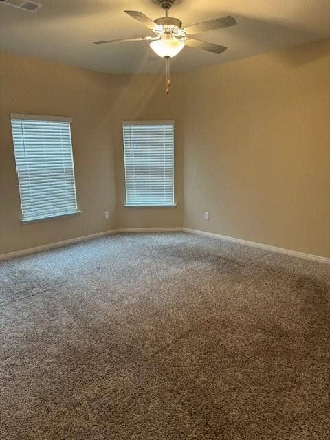 Carpeted flooring with multiple windows featuring blinds and a ceiling fan with integrated lighting