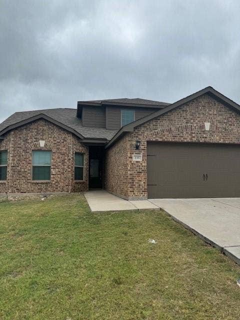 Brick veneer exterior with a brown garage door, dark shingle roof, and a concrete driveway