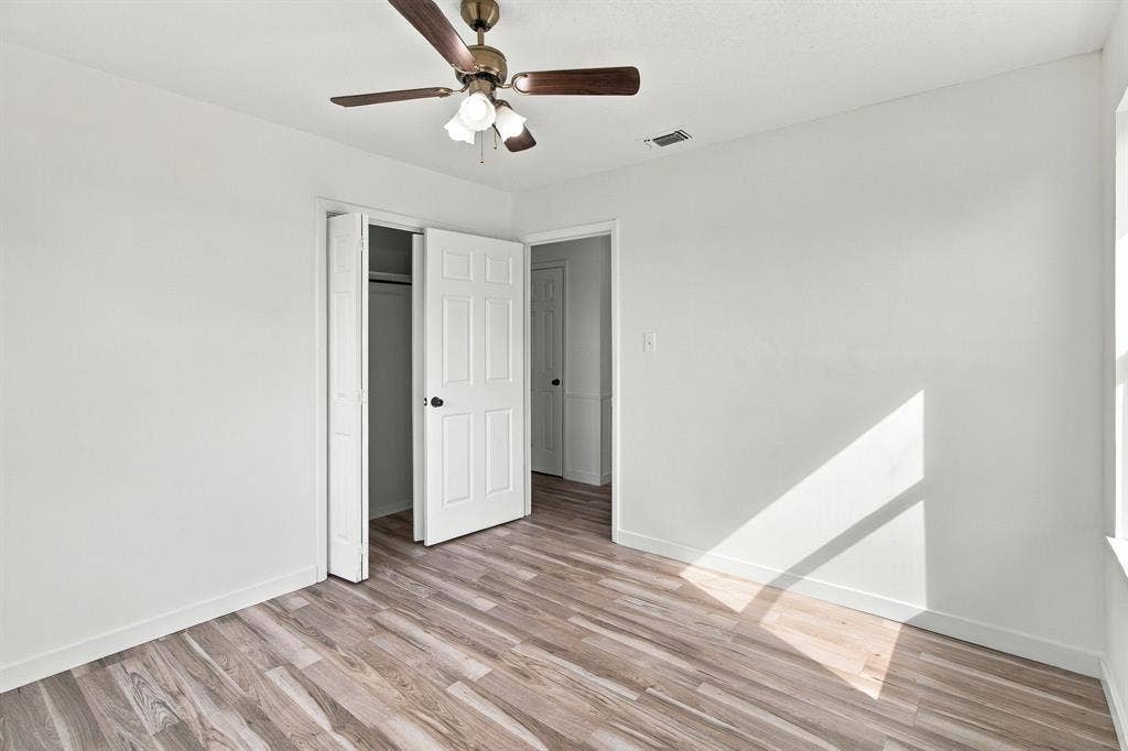 LVP  flooring, ceiling fan with light fixture, white interior paint, bi-fold closet doors, and recessed window