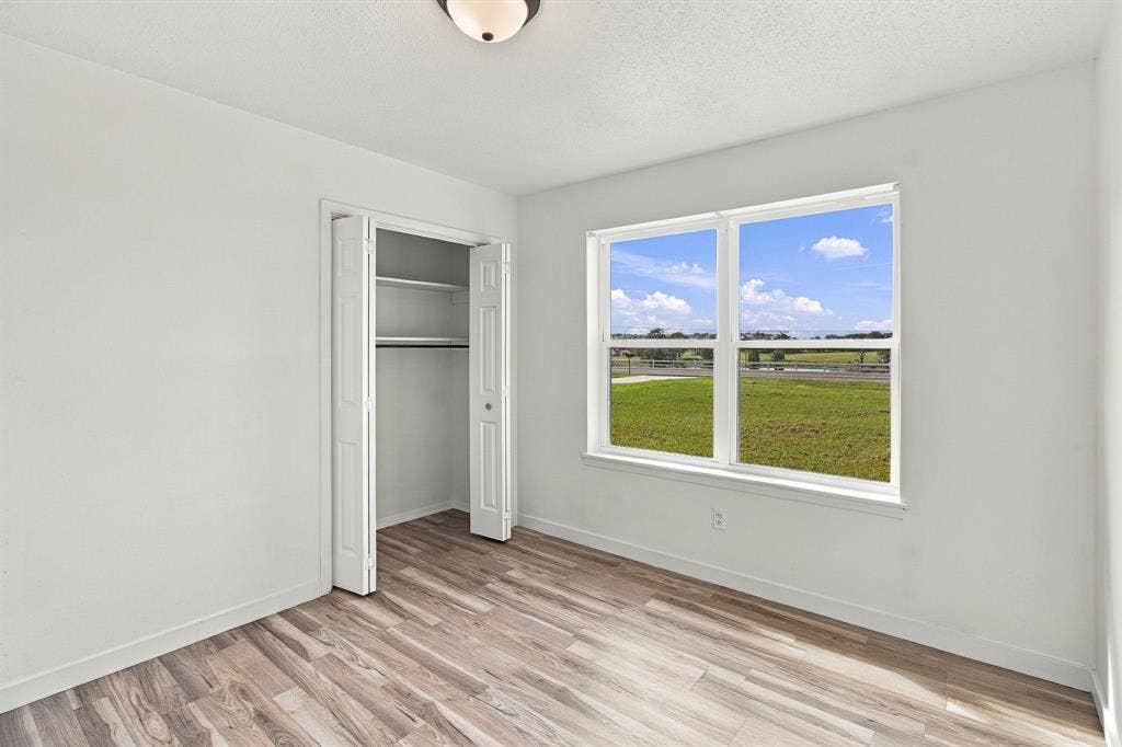 LVP flooring, white walls, and a bi-fold closet with shelving